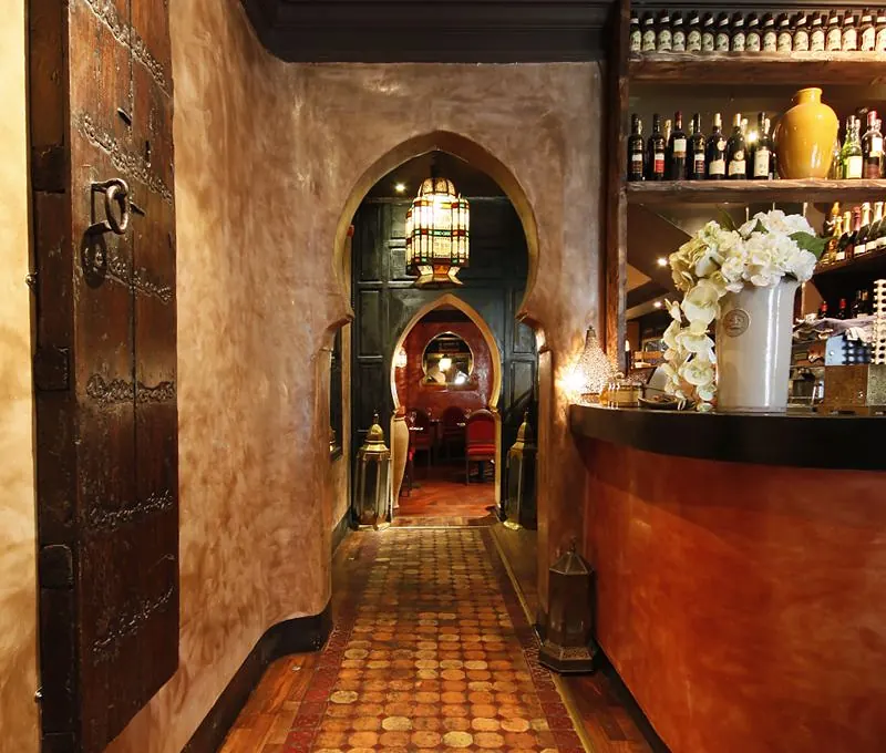 The tiled entrance and bar at Dada, framed by a Moorish arch